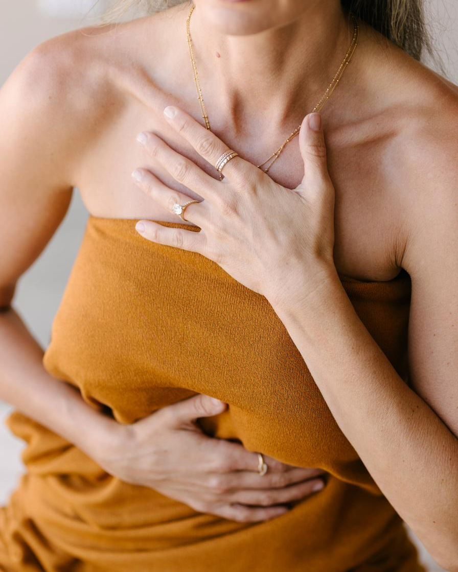 Elle with her hands resting at her chest and belly