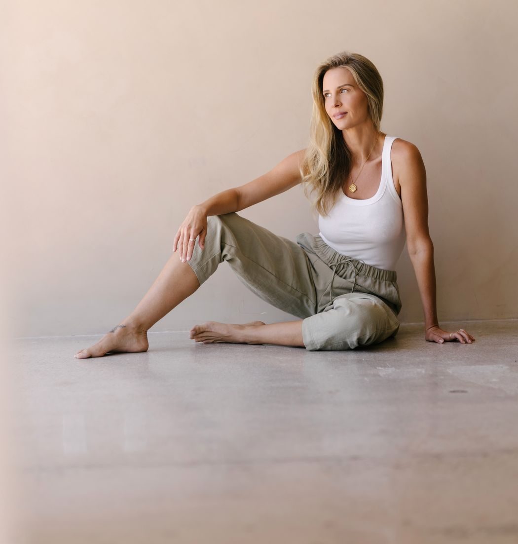 Elle kneeling on the floor, one hand at her heart