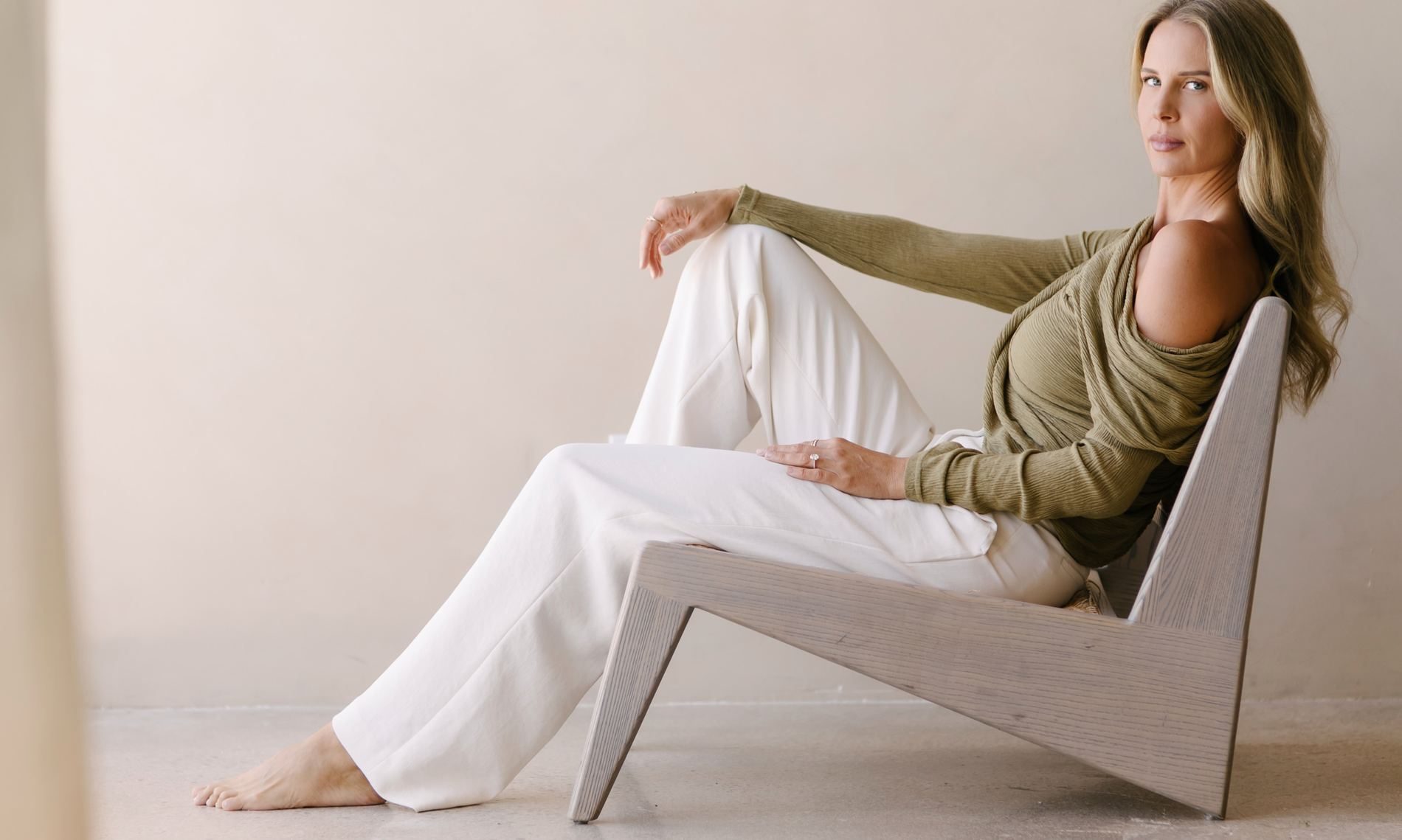 Elle Wilk seated in a sculptural chair, looking directly at the camera