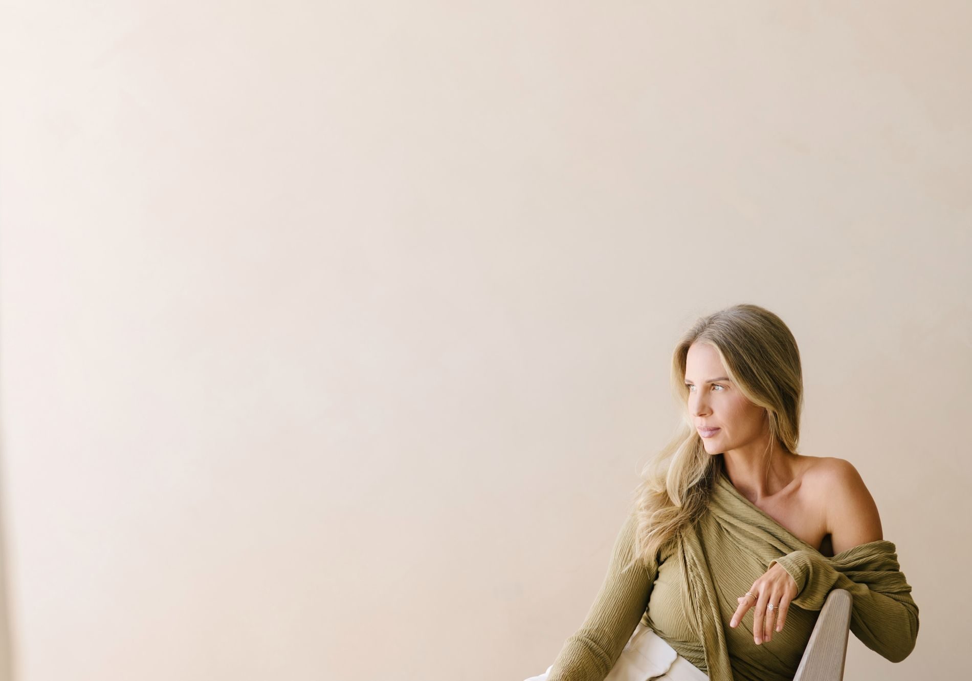 Elle Wilk seated in a sculptural chair, looking out