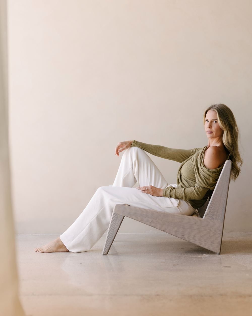 Elle seated in a sculptural chair